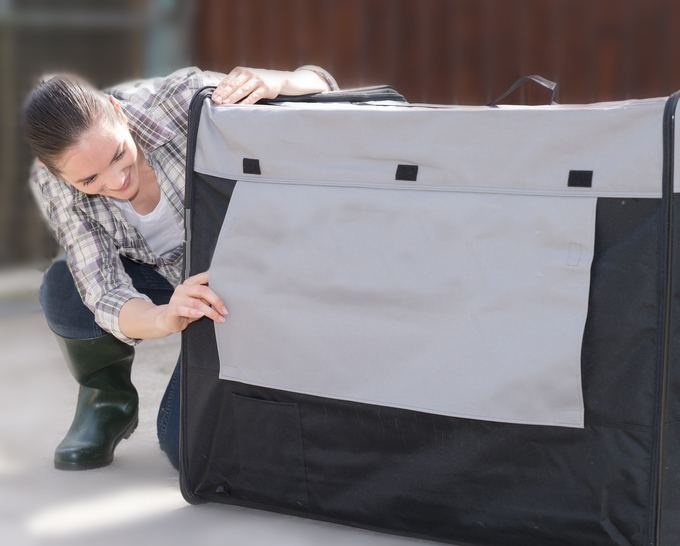 woman peeking thru a dog crate cover
